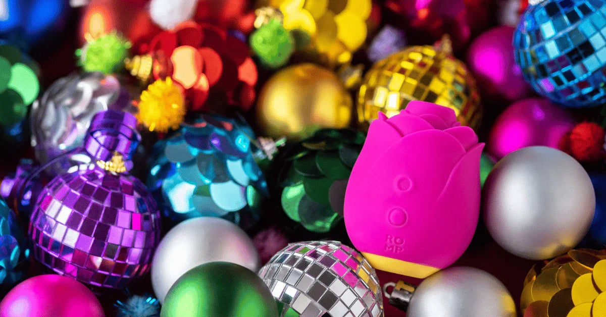 Pink rose-shaped massager surrounded by colorful Christmas ornaments
