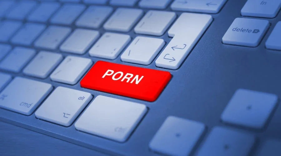 Close-up of keyboard with a red button labeled 'PORN' in focus, representing adult content online.