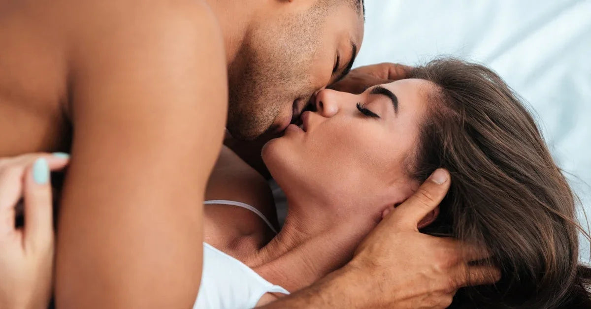 Romantic couple kissing passionately in bed, close-up, intimate bedroom moment