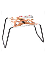 Fetish Fantasy Series The Incredible Sex Stool produktbilde med emballasje plassert på stolen. Svart metallram med transparent sete, hvit bakgrunn.