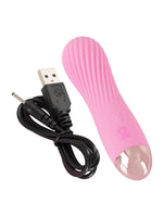Cuties rosa minivibrator med medfølgende svart USB-ladekabel plassert ved siden av mot hvit bakgrunn.