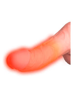 Nærbilde av dildoens tupp med oransje glød som illustrerer oppvarmingsfunksjonen til kroppstemperatur mot hvit bakgrunn.