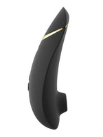 Womanizer Premium 2 sett fra motsatt side, med buet profil, gulldetalj og synlige kontrollknapper.