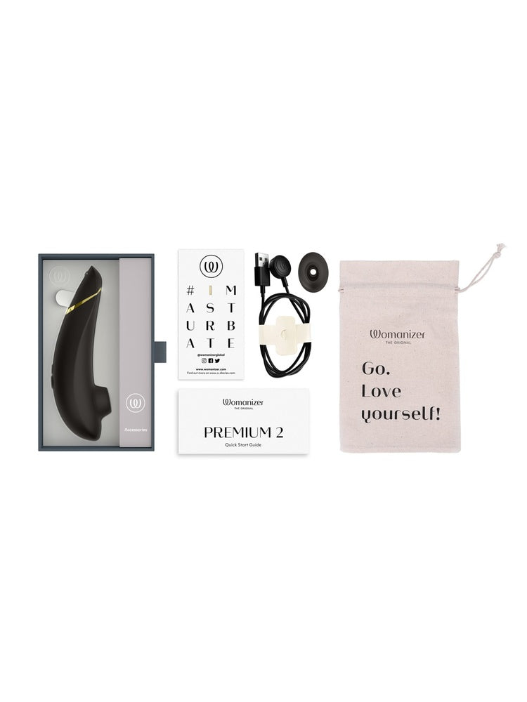 Innhold i pakken: Womanizer Premium 2, ekstra stimulatorhode, USB-ladekabel, oppbevaringspose, quick start guide og kort.