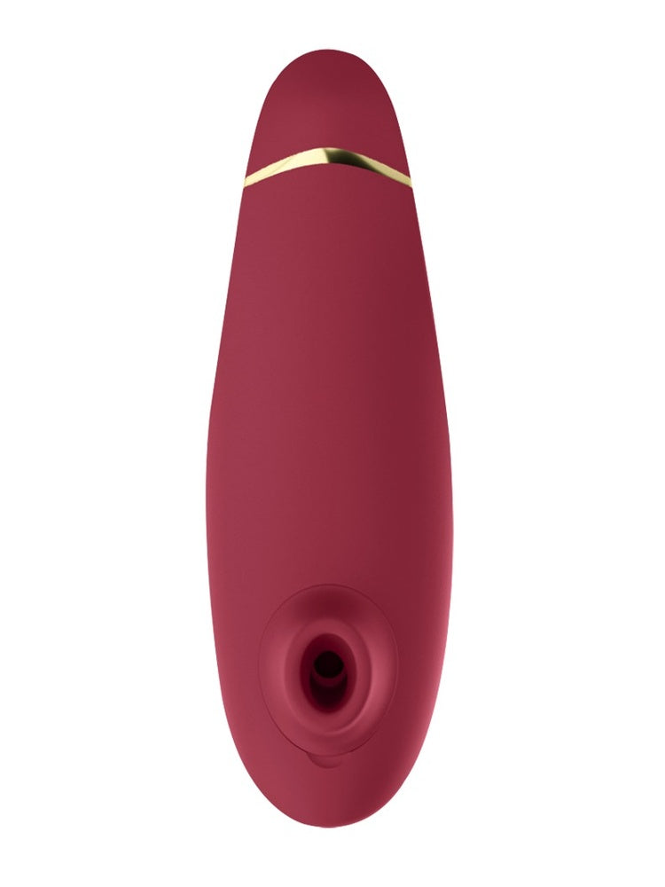 Womanizer Premium 2 i bordeauxrød, sett forfra med oval form og gulldetalj.