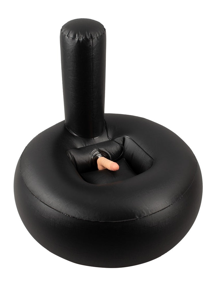 Oppblåsbar sexpute med realistisk vibrator, sett ovenfra. Svart donutformet pute med støtte og hudfarget vibrator i midten, hvit bakgrunn.