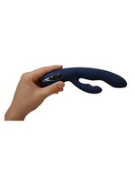 Hånd som holder Svakom Aylin rabbitvibrator for å illustrere størrelse og ergonomi. Vibratoren holdes komfortabelt i én hånd med fingrene rundt sølvfarget kontrollknapp.