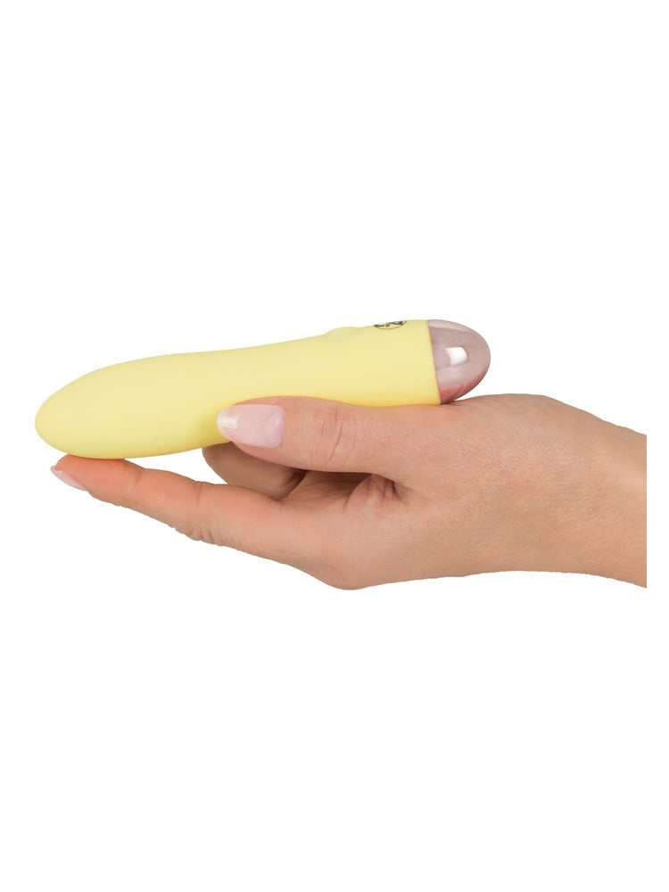 Cuties gul minivibrator liggandes i en hand, visar produktens kompakta storlek med roséguldsfärgad botten och You2Toys-logotyp synlig.