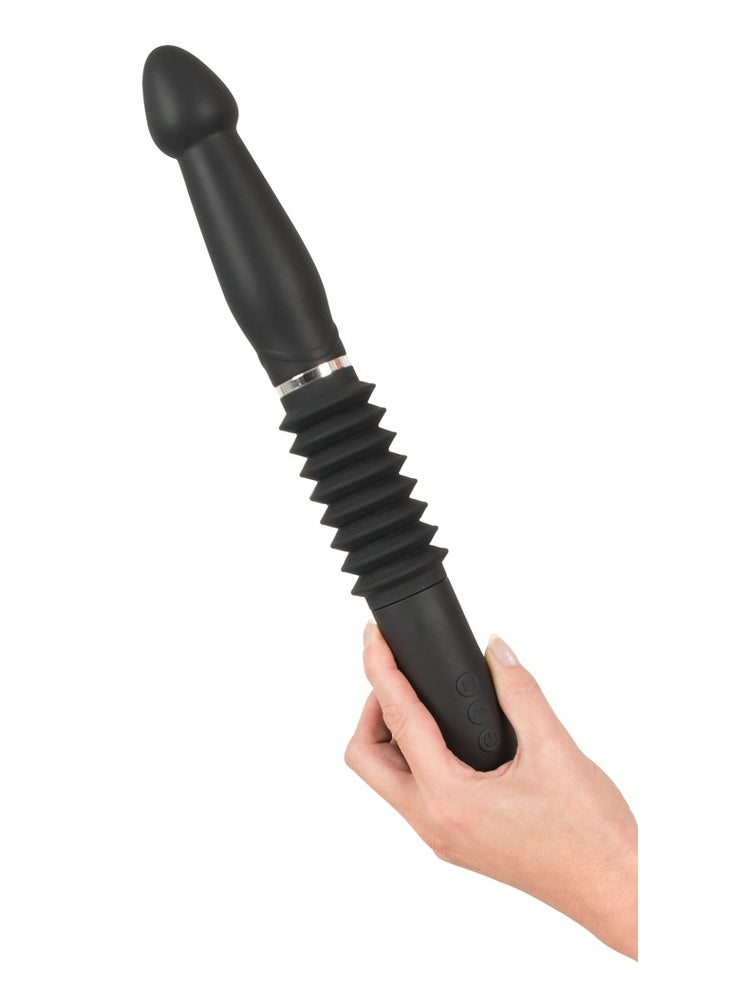 Hånd holder RC Fucking Machine med fullt uttrekt thrusting-mekanisme, viser produktets maksimale lengde med rillet belg.
