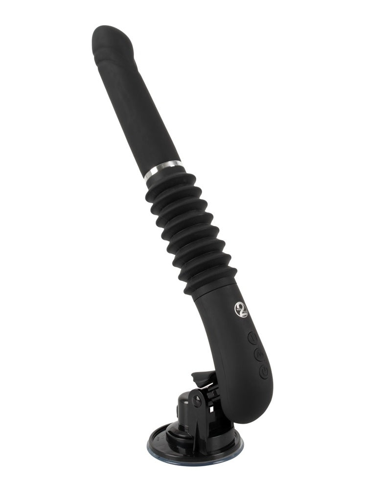 RC Fucking Machine 2.0 sett fra siden i ca. 45° vinkel. Viser hele produktet: sugekopp, motorenhet med knapper, belg og svart silikon-dildo.