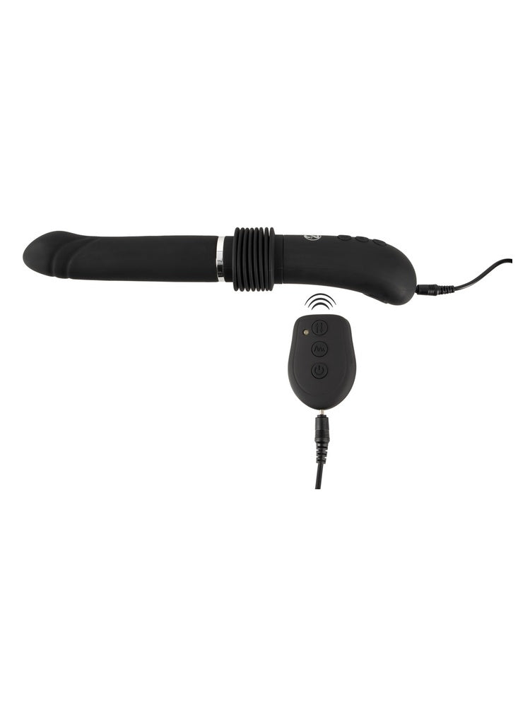 RC Fucking Machine 2.0 liggende horisontalt, koblet til ladekabel. Viser ladeport og tilkobling.