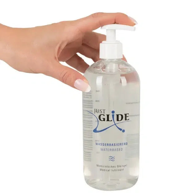 Hand holding large bottle of Just Glide water-based personal lubricant with pump dispenser