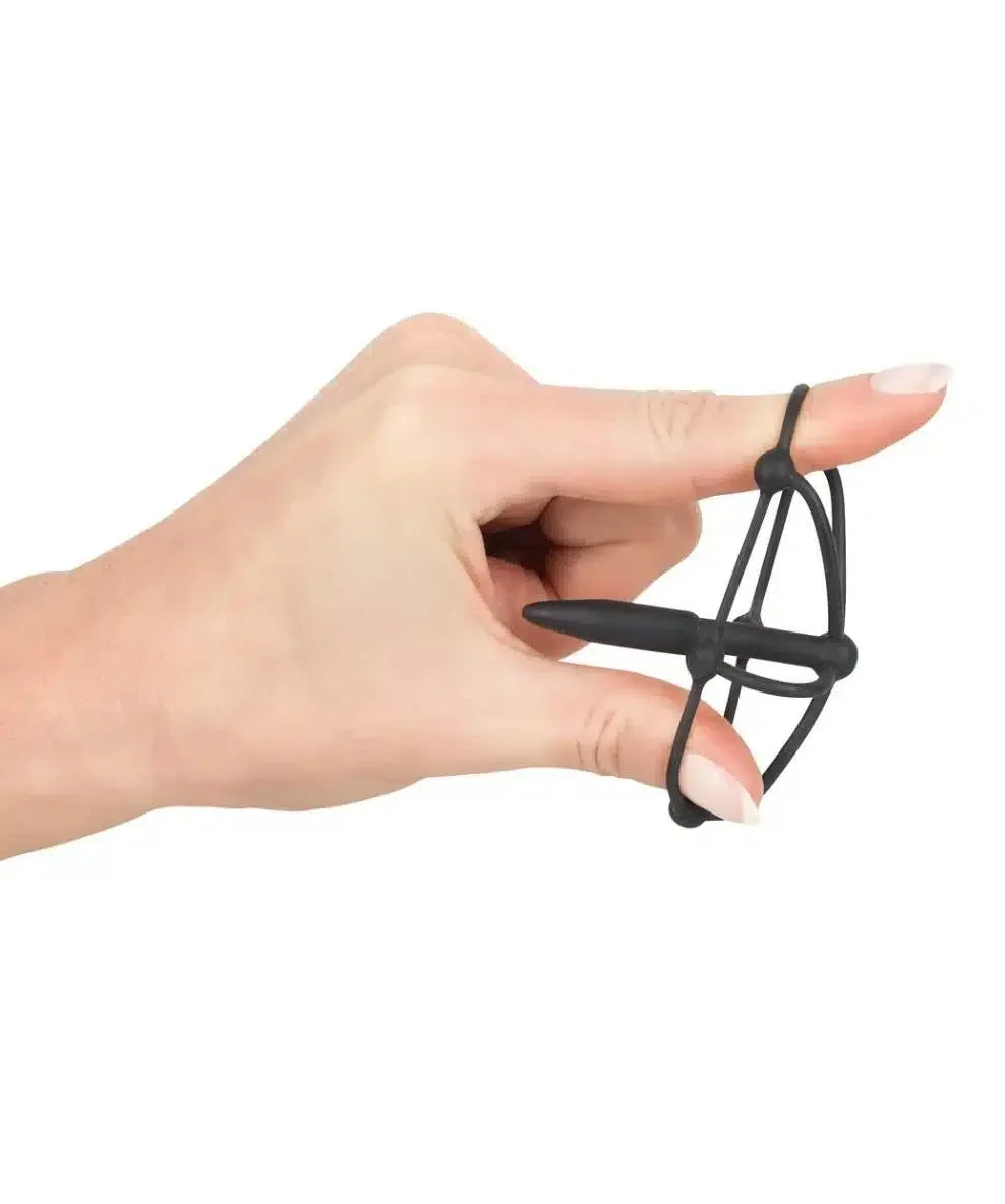 Hand holding small black silicone novelty mini bow and arrow toy against white background