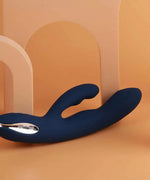 Blue silicone dual-ended personal massager on beige background