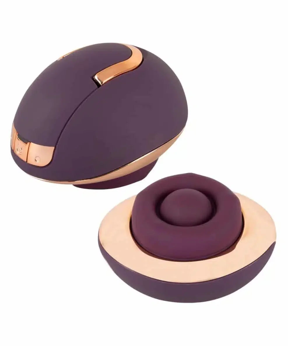 Purple and gold ergonomic massage device with charging base, modern intimate wellness product