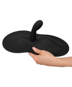 Hand holding a black silicone adult toy with curved design and flared base