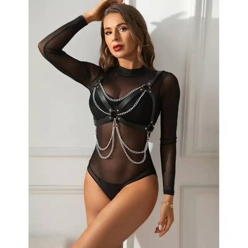 Woman in black sheer bodysuit with leather harness and silver chains, sexy lingerie style