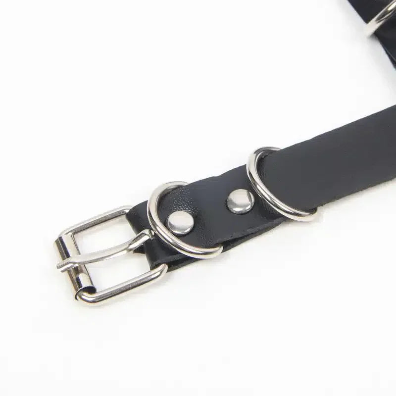 Adjustable black faux leather strap with metal buckle and D-rings for bondage accessories