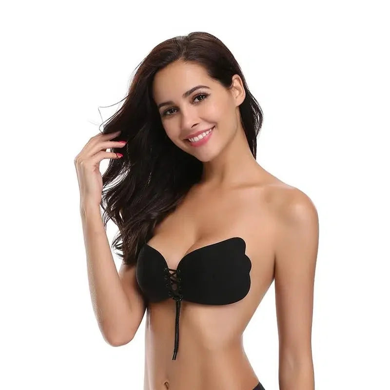 Woman wearing a strapless black adhesive bra with lace-up front, suitable for backless outfits