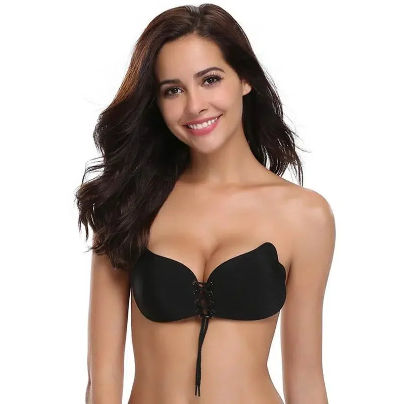 Woman wearing a strapless black adhesive bra with lace-up front, ideal for invisible support