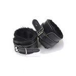 Black faux fur lined wrist restraints with adjustable buckle straps on white background