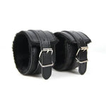 Pair of black faux leather adjustable wrist cuffs with soft lining