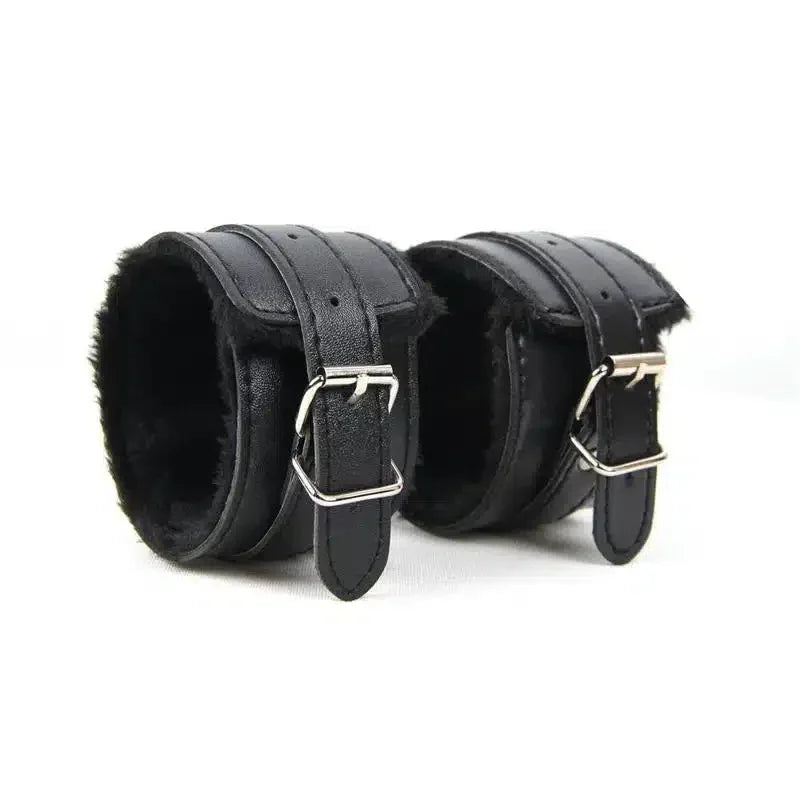 Pair of black faux leather adjustable wrist cuffs with soft lining