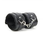 Black faux leather wrist restraints with soft lining and metal chain connector