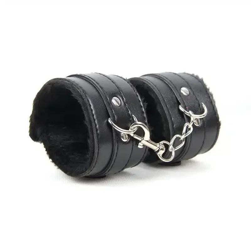 Black faux leather wrist restraints with soft lining and metal chain connector