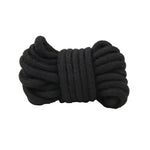 Coiled black bondage rope on white background, soft cotton restraint accessory.