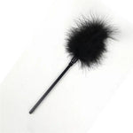 Black feather tickler on white background, sensual accessories, intimate couples product
