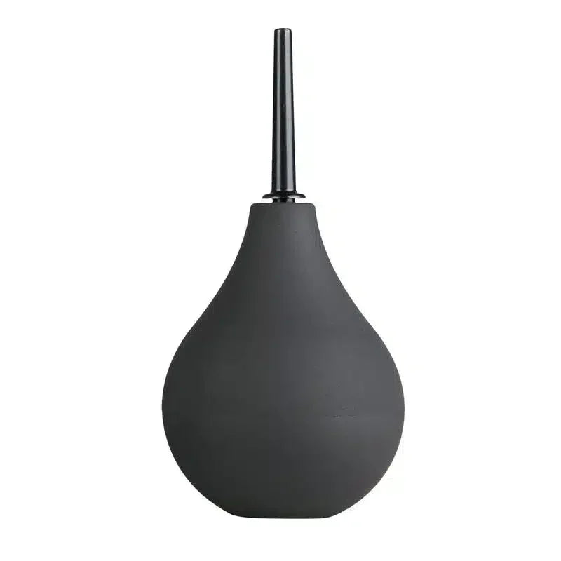 Black silicone bulb enema with narrow nozzle on white background
