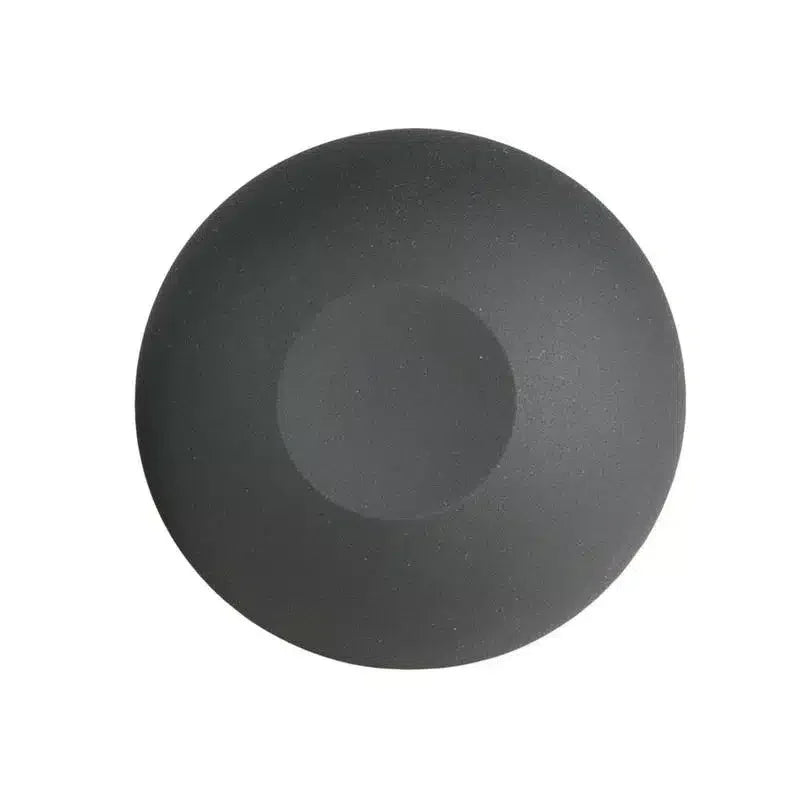 Round matte black silicone object with a smooth, seamless surface on white background