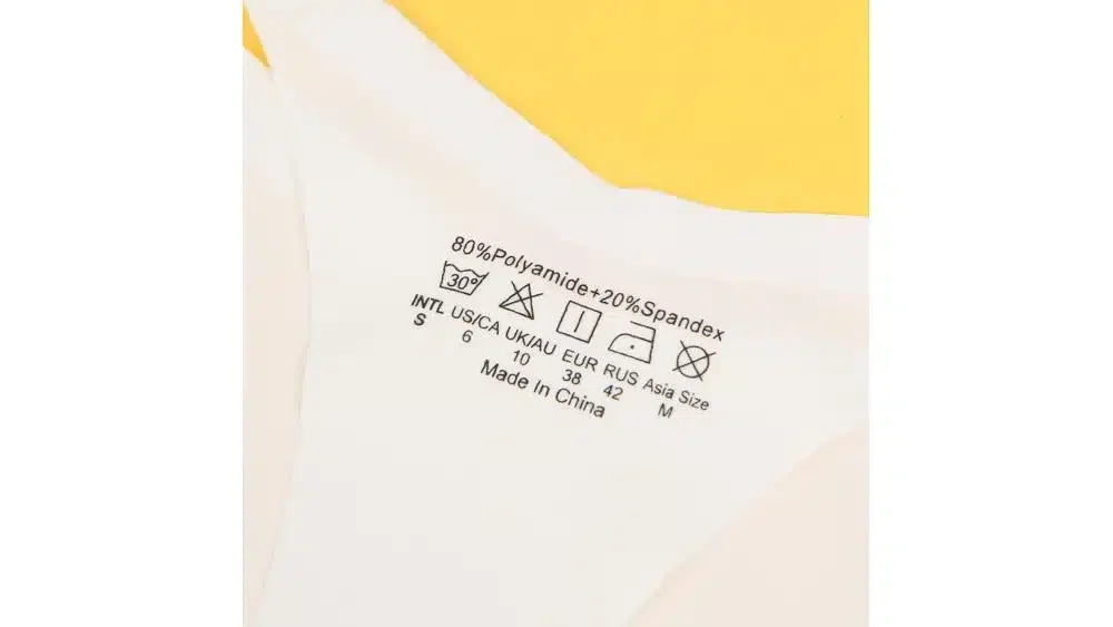 White underwear clothing label with fabric composition and washing instructions on yellow background