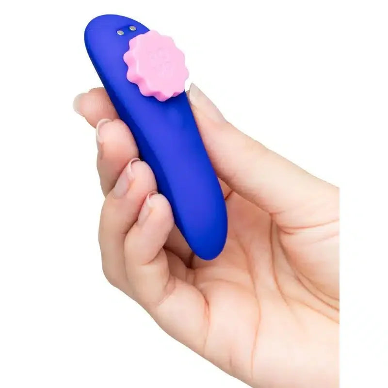 Hand holding a blue silicone personal massager with a pink textured control knob