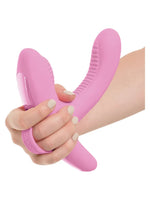 Hånd som holder 3Some Rock N' Grind vibrator med posisjoneringsrem rundt håndleddet