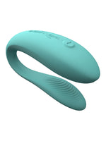 We-Vibe Sync Lite sett ovenfra i skrå vinkel, med buet C-form, glatt overflate med logo og knapp, samt teksturert indre arm.