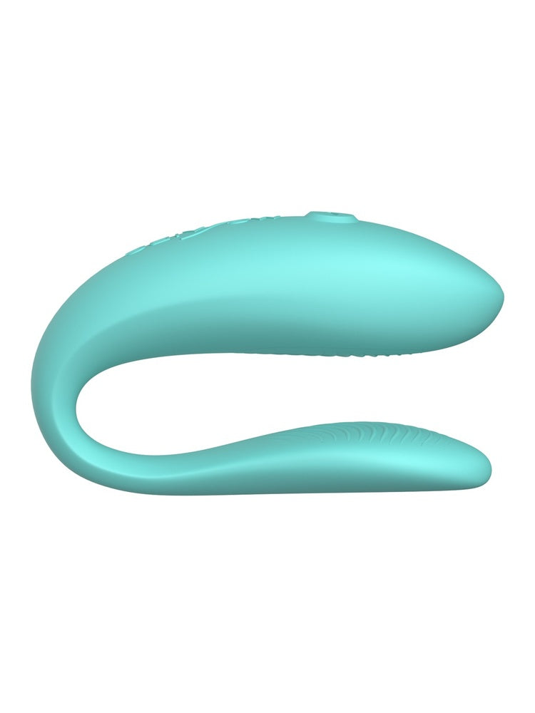 We-Vibe Sync Lite sett fra siden, med S-formet design, teksturert indre arm og glatt ytre del med kontrollknapp.
