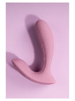 Svakom Erica trusevibrator med vannperler på overflaten, liggende på rosa bakgrunn, viser vanntetthet