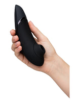 Hånd som holder Womanizer Next i sort, som viser størrelse og ergonomi.