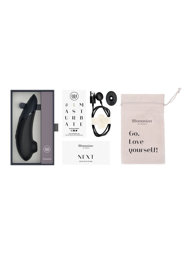 Innhold i pakken: Womanizer Next, ekstra stimulatorhode, USB-ladekabel, oppbevaringspose, quick start guide og kort.