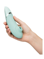 Hånd som holder Womanizer Next for å vise størrelse og ergonomi.