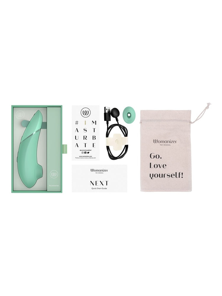 Innhold i pakken: Womanizer Next, ekstra stimulatorhode, USB-ladekabel, oppbevaringspose, quick start guide og kort.