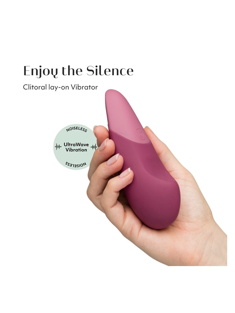 Womanizer Vibe klitorisstimulator i hånd med tekst “Enjoy the Silence” og ikon for UltraWave vibrasjon