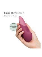 Womanizer Vibe klitorisstimulator i hånd med tekst “Enjoy the Silence” og ikon for UltraWave vibrasjon