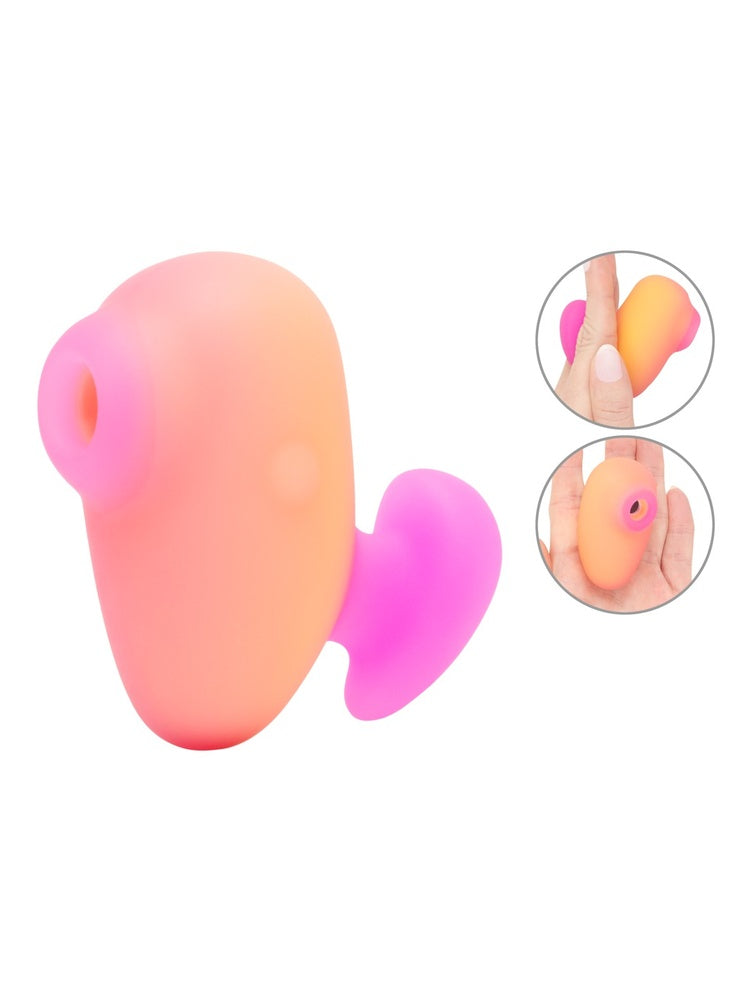 ROMP Kiss klitorisstimulator i oransje-rosa, sett fra siden med stimulatorhode og hjertformet base. Innfelt bilde viser størrelse i hånd.