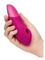 Hånd som holder Womanizer Enhance forfra, med stimulatorhode synlig.