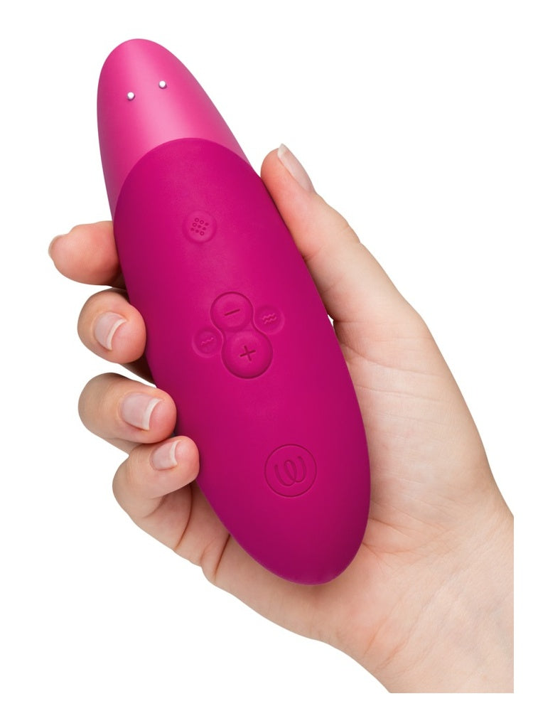 Hånd som holder Womanizer Enhance bakfra, med kontrollpanel synlig.