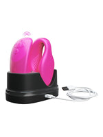 We-Vibe Chorus parvibrator og fjernkontroll i rosa plassert i svart ladedokking med tilkoblet USB-kabel.