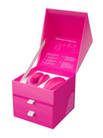 We-Vibe Chorus gaveeske åpnet forfra, med vibrator og fjernkontroll i rosa formstøpt interiør og velkomsttekst på innsiden av lokket.